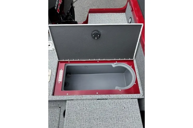 Slide: The Image of 2023 Tracker Targa V-19 Combo boat storage compartment with open lid, featuring gray interior. - 14