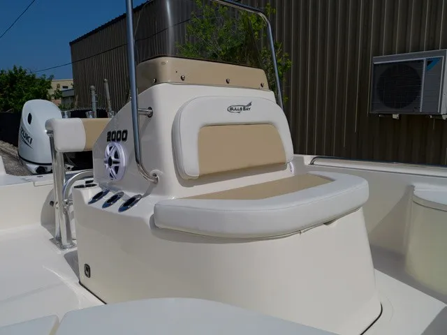 Slide: The Image of The image shows the cockpit of a Bulls Bay 2000 boat with beige upholstery. - 34