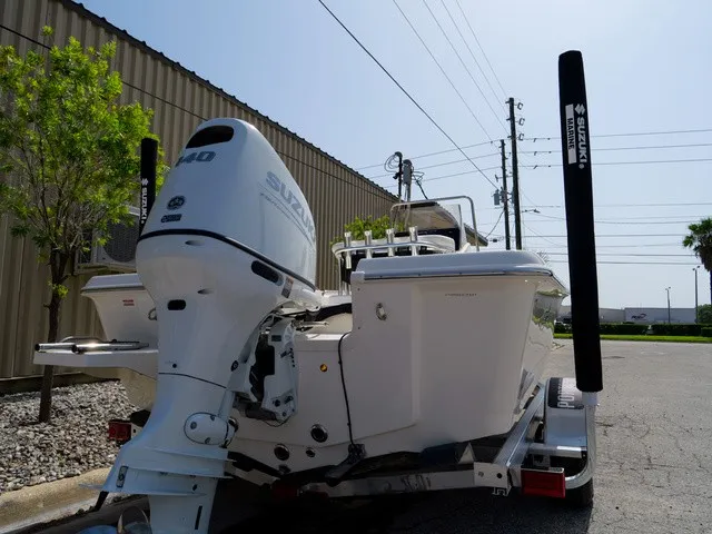 Slide: The Image of Bulls Bay 2000 boat from 2027 with Suzuki outboard motor, on a trailer in an urban area. - 12