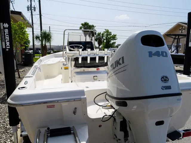 Slide: The Image of A Bulls Bay 2000 boat with a Suzuki 140 outboard motor, parked on a gravel lot. - 36