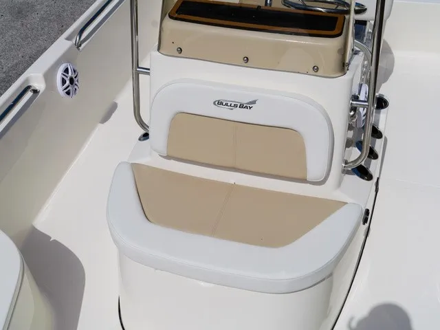 Slide: The Image of The image shows the seating area of a Bulls Bay 2000 boat with beige and white upholstery. - 22