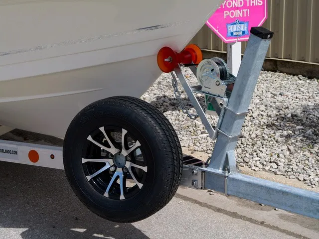 Slide: The Image of A boat trailer with a black wheel and a winch holding the bow of a boat. - 30