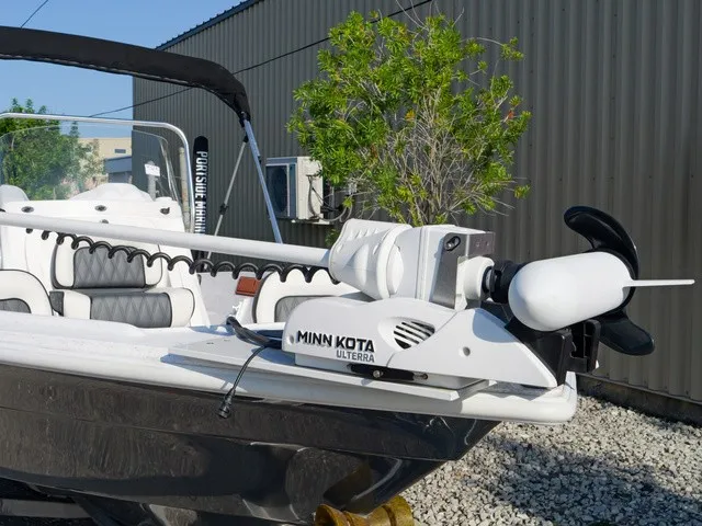 Slide: The Image of A 2023 ALK2 Powerboats 18CRS with Minn Kota Ulterra motor, parked in an outdoor area. - 2