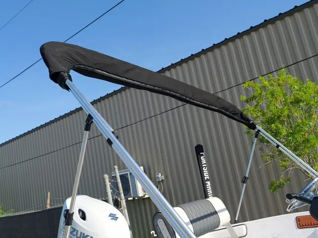 Slide: The Image of A boat with a black bimini top and Suzuki motor, parked in front of a building. - 9