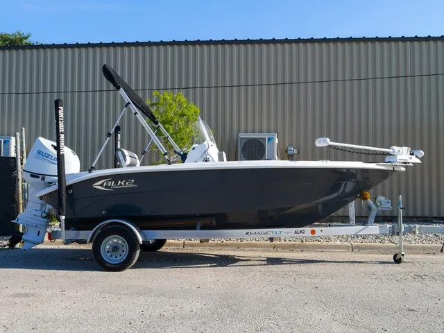 The Image of A 2023 ALK2 Powerboats 18CRS on a trailer, with Suzuki outboard motor, parked in front of a building. - 0