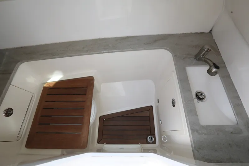 Slide: The Image of 2016 Boston Whaler 320 Vantage boat interior with sink and wooden accents. - 26