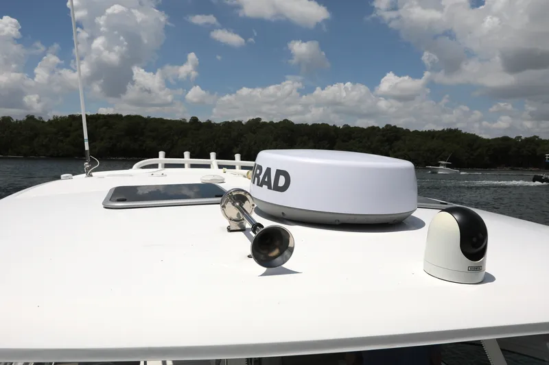 Slide: The Image of 2016 Boston Whaler 320 Vantage boat with radar and camera on deck, under a cloudy sky. - 25