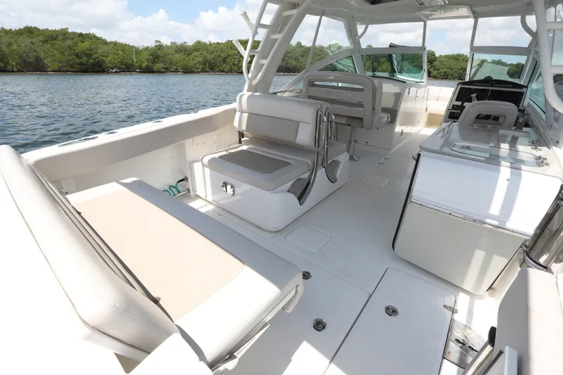 Slide: The Image of 2016 Boston Whaler 320 Vantage boat interior with seating and helm, on calm water. - 12