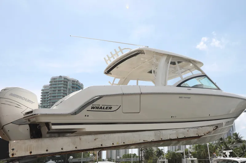 Slide: The Image of 2016 Boston Whaler 320 Vantage boat on lift, with cityscape background. - 1