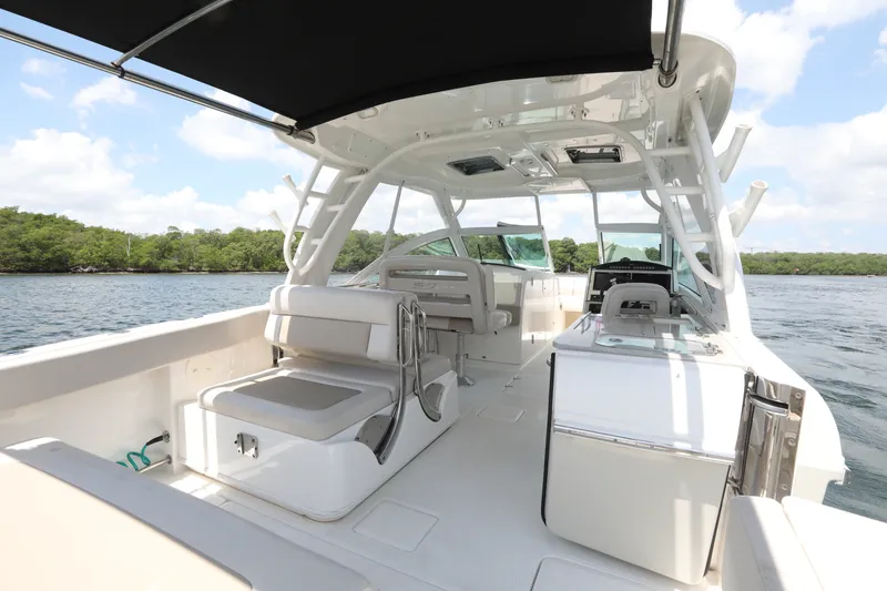 Slide: The Image of 2016 Boston Whaler 320 Vantage boat interior with seating and helm, on calm water. - 11