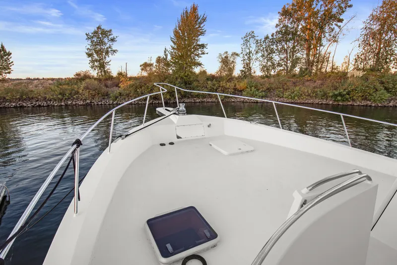 Slide: The Image of Bow view of 2006 Solander Eclipse Steel Trawler on calm river with trees. - 63