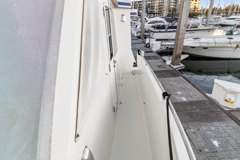 Slide: The Image of Side view of 2006 Solander Eclipse Steel Trawler docked at marina with other boats. - 58