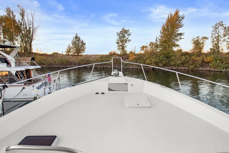 Slide: The Image of Bow view of 2006 Solander Eclipse Steel Trawler on calm river, surrounded by trees. - 64