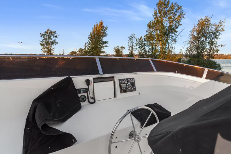 Slide: The Image of Helm of 2006 Solander Eclipse Steel Trawler with steering wheel and control panel, near shoreline. - 57