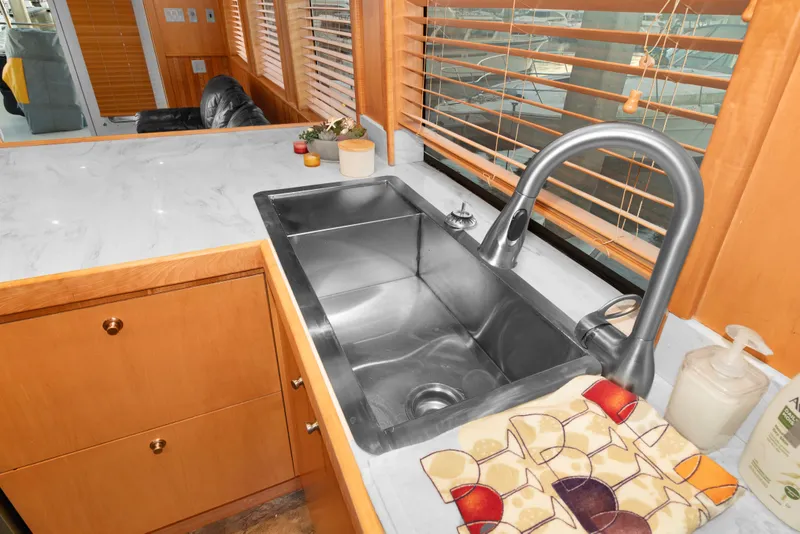 Slide: The Image of Kitchen sink area in 2006 Solander Eclipse Steel Trawler, featuring modern fixtures and wooden cabinetry. - 9