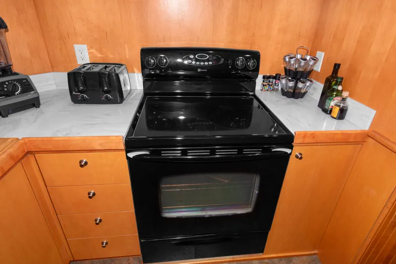 Slide: The Image of Kitchen interior of 2006 Solander Eclipse Steel Trawler with black stove and wooden cabinets. - 10