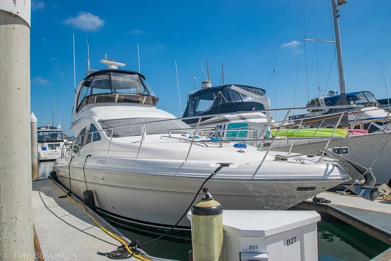 Slide: The Image of 2005 Sea Ray 420 Sedan Bridge yacht docked at marina under clear blue sky. - 1