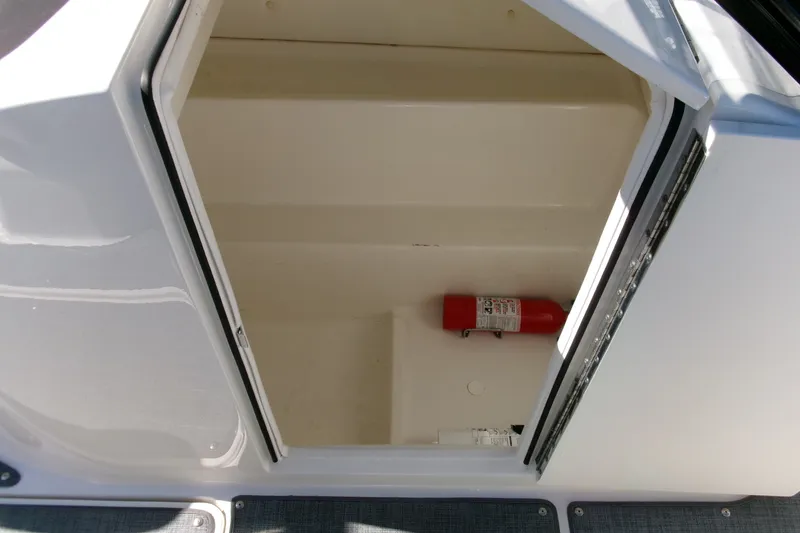 Slide: The Image of Storage compartment with fire extinguisher in 2022 Bayliner VR6 Bowrider OB boat. - 11