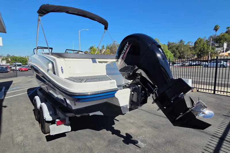 Slide: The Image of 2022 Bayliner VR6 Bowrider OB with Mercury outboard motor on trailer, parked outdoors. - 3