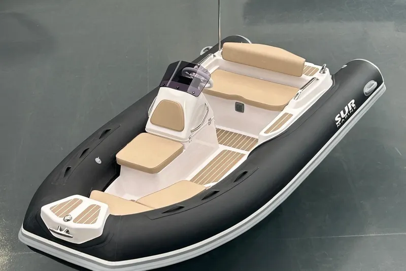 Slide: The Image of Das Bild zeigt ein modernes Schlauchboot mit beigen Sitzen und schwarzem Rumpf. - 1