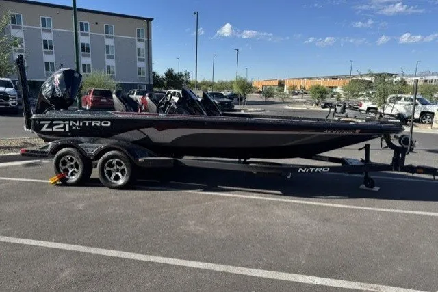 Slide: The Image of 2024 Nitro Z21 XL Pro boat parked in a lot, showcasing sleek design and modern features. - 2
