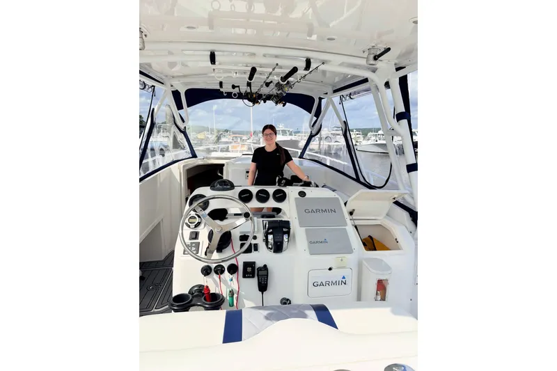 Slide: The Image of Person at helm of 2001 Intrepid 348 Walkaround boat, featuring Garmin navigation equipment. - 8