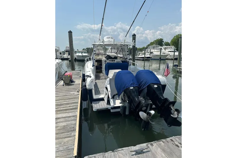 Slide: The Image of 2001 Intrepid 348 Walkaround boat docked with twin outboard engines, marina background. - 5