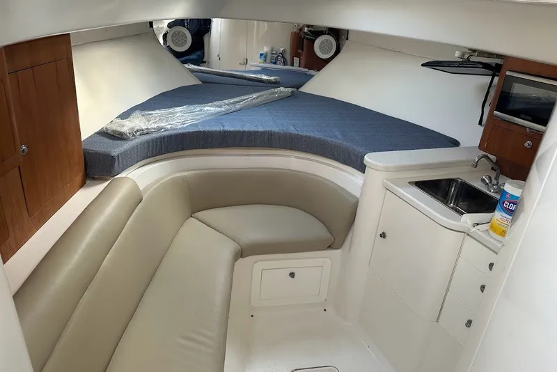 Slide: The Image of 2001 Intrepid 348 Walkaround cabin interior with seating, kitchenette, and bed. - 12