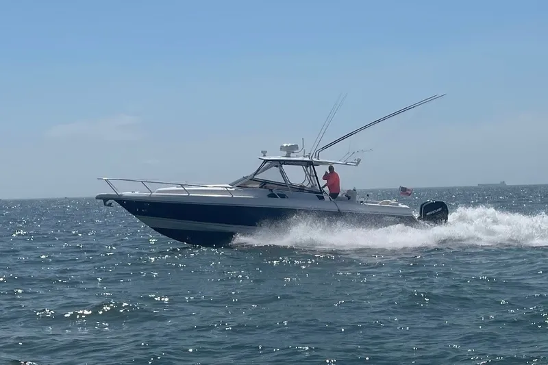 Slide: The Image of 2001 Intrepid 348 Walkaround boat cruising on open water under clear skies. - 3