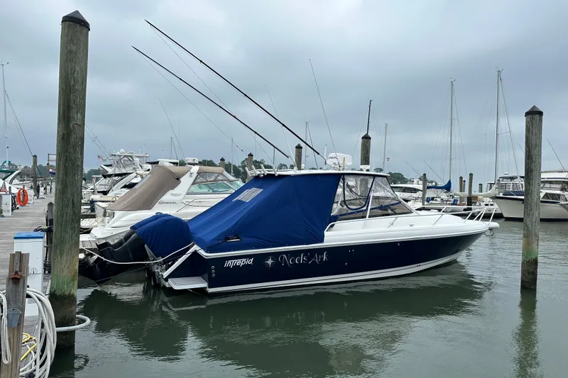 Slide: The Image of 2001 Intrepid 348 Walkaround boat docked at marina with blue cover. - 1