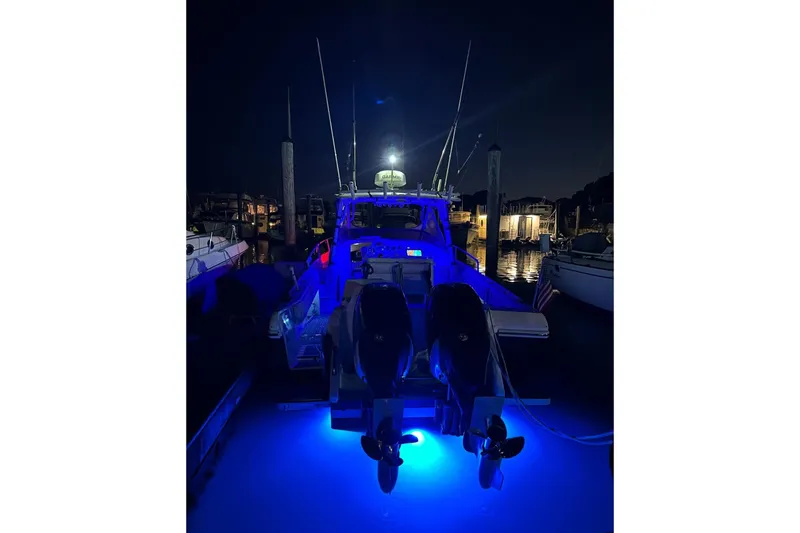 Slide: The Image of 2001 Intrepid 348 Walkaround boat illuminated at night with blue underwater lights. - 4