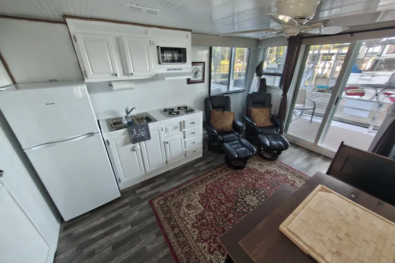 Slide: The Image of Interior of 2023 Catamaran Cruisers 1245 with kitchen, seating, and large windows. - 1