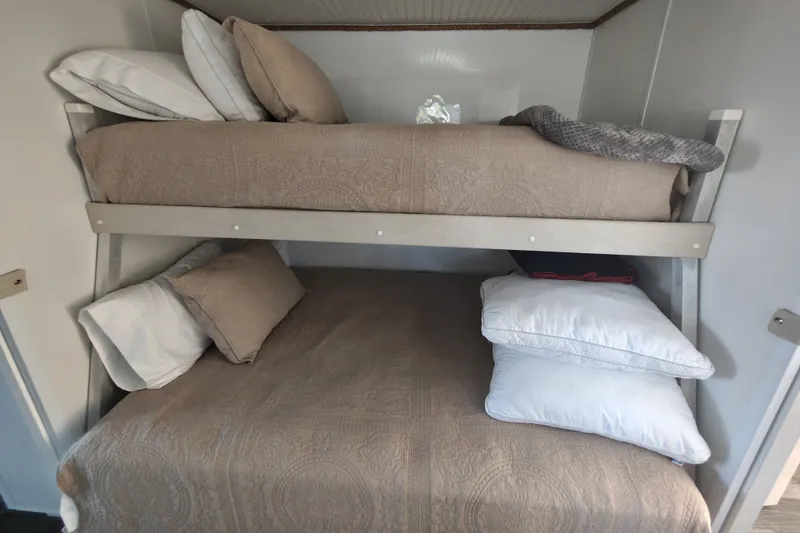 Slide: The Image of Bunk beds in 2023 Catamaran Cruisers 1245, featuring cozy bedding and pillows. - 5