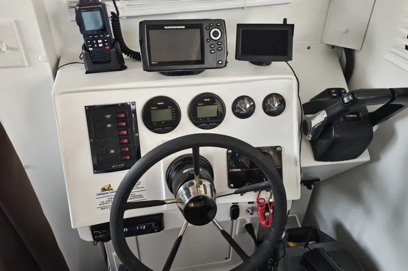 Slide: The Image of Control panel of 2023 Catamaran Cruisers 1245 with steering wheel and navigation instruments. - 4