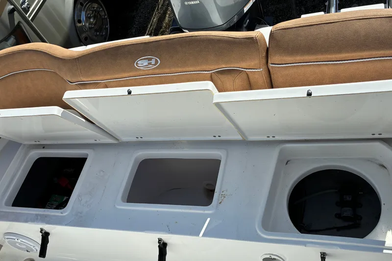 Slide: The Image of 2023 Sea Hunt Ultra 229 boat interior with storage compartments and seating. - 66