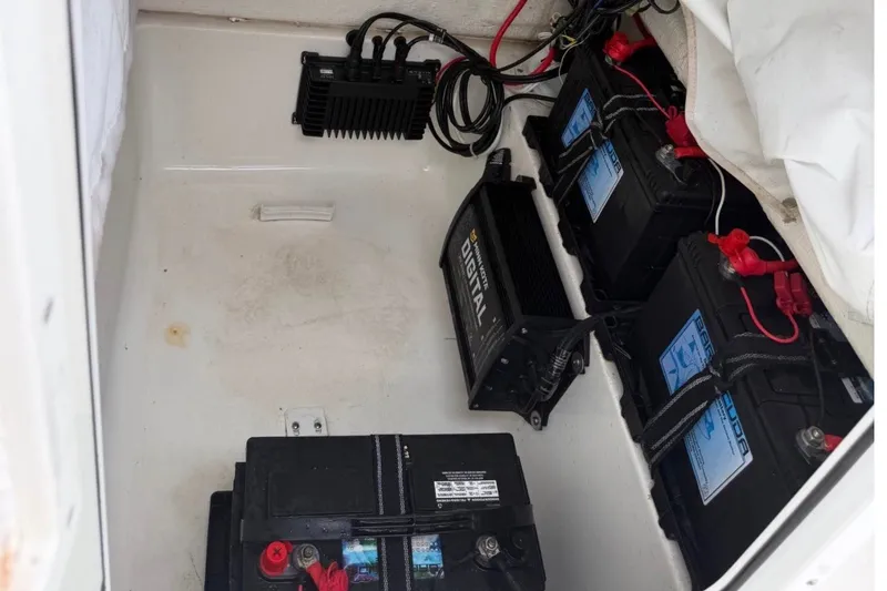 Slide: The Image of Battery compartment of 2023 Sea Hunt Ultra 229 boat with multiple batteries and wiring. - 7
