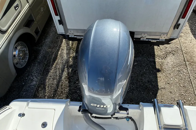 Slide: The Image of 2023 Sea Hunt Ultra 229 boat with Yamaha 200 outboard motor, parked near RV. - 12