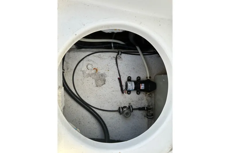 Slide: The Image of 2023 Sea Hunt Ultra 229 boat compartment with wiring and pump system. - 68