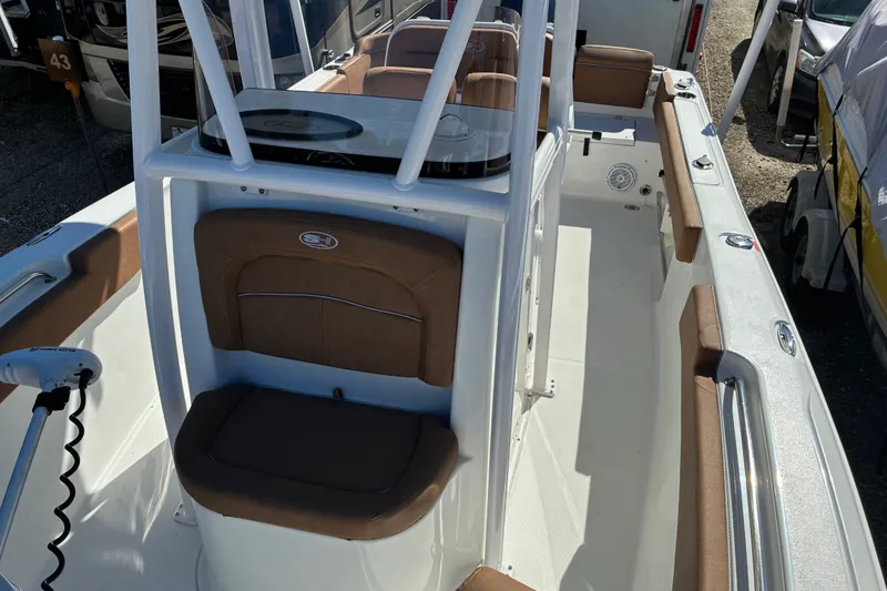 Slide: The Image of 2023 Sea Hunt Ultra 229 boat interior with brown seating and white console. - 28