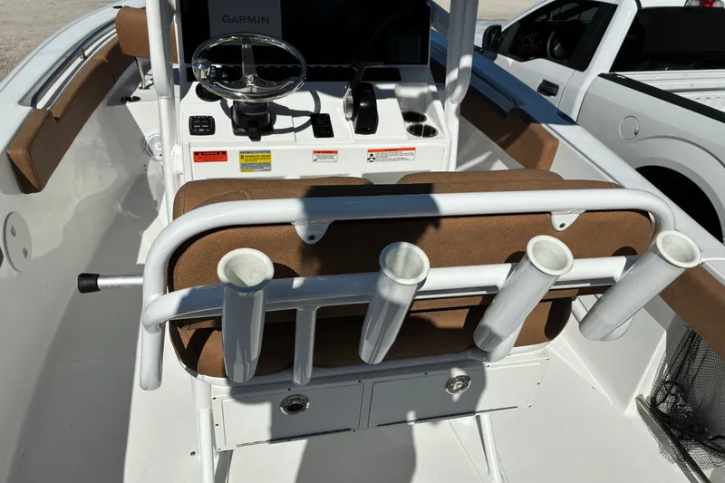 Slide: The Image of 2023 Sea Hunt Ultra 229 boat interior with steering console and rod holders. - 17