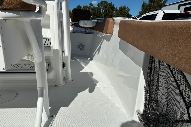 Slide: The Image of 2023 Sea Hunt Ultra 229 boat interior with cushioned seating and storage net. - 49