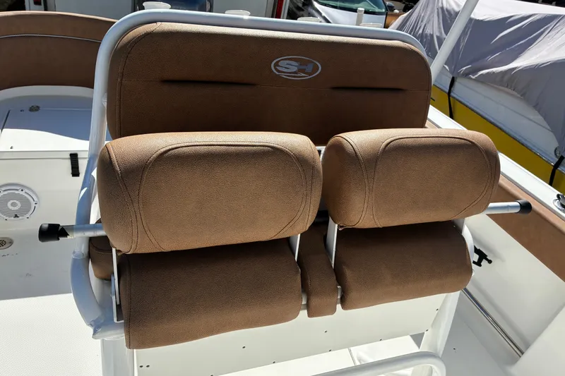 Slide: The Image of 2023 Sea Hunt Ultra 229 boat with brown cushioned seating and white frame. - 62