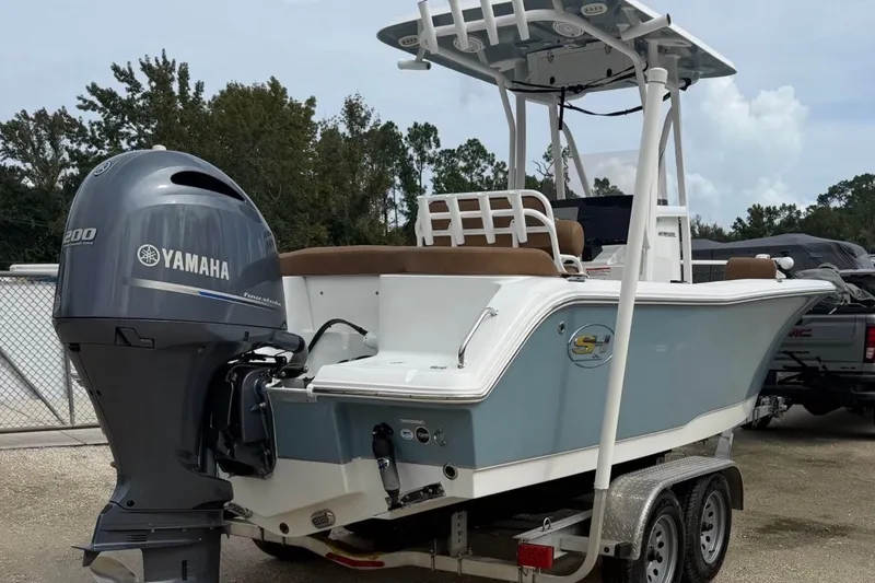 The Image of 2023 Sea Hunt Ultra 229 boat with Yamaha engine on trailer, parked outdoors. - 0