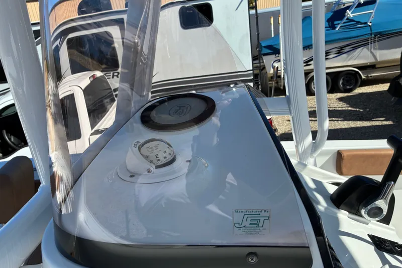 Slide: The Image of 2023 Sea Hunt Ultra 229 boat console with compass and controls in a marina setting. - 38
