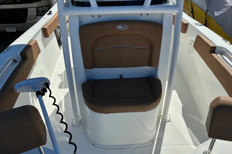 Slide: The Image of 2023 Sea Hunt Ultra 229 boat interior with brown seating and white deck. - 34