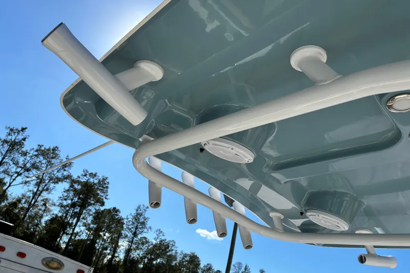 Slide: The Image of 2023 Sea Hunt Ultra 229 boat underside with rod holders and clear sky background. - 21