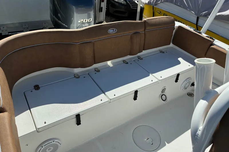 Slide: The Image of 2023 Sea Hunt Ultra 229 boat interior with brown seating and storage compartments. - 61