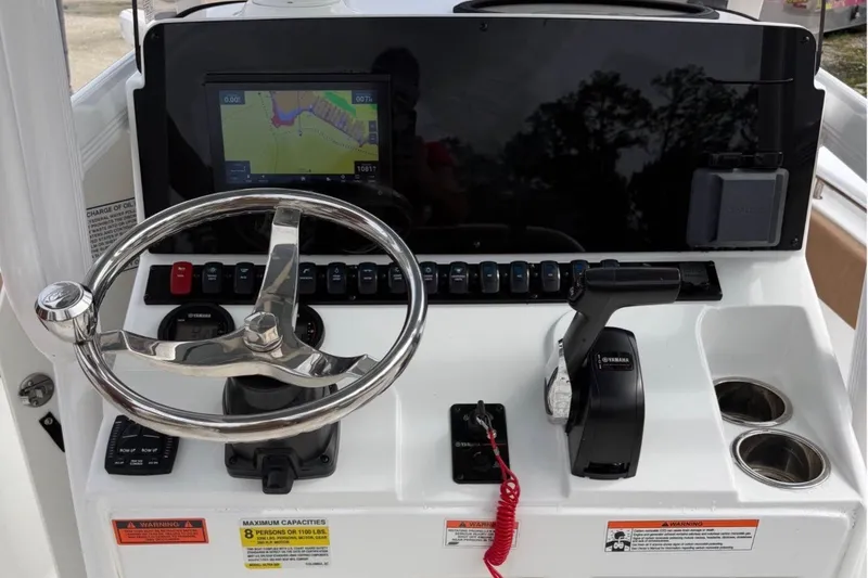 Slide: The Image of 2023 Sea Hunt Ultra 229 boat dashboard with steering wheel and navigation display. - 5