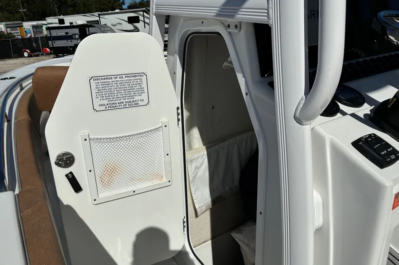 Slide: The Image of 2023 Sea Hunt Ultra 229 boat interior with open storage compartment and safety notice. - 40