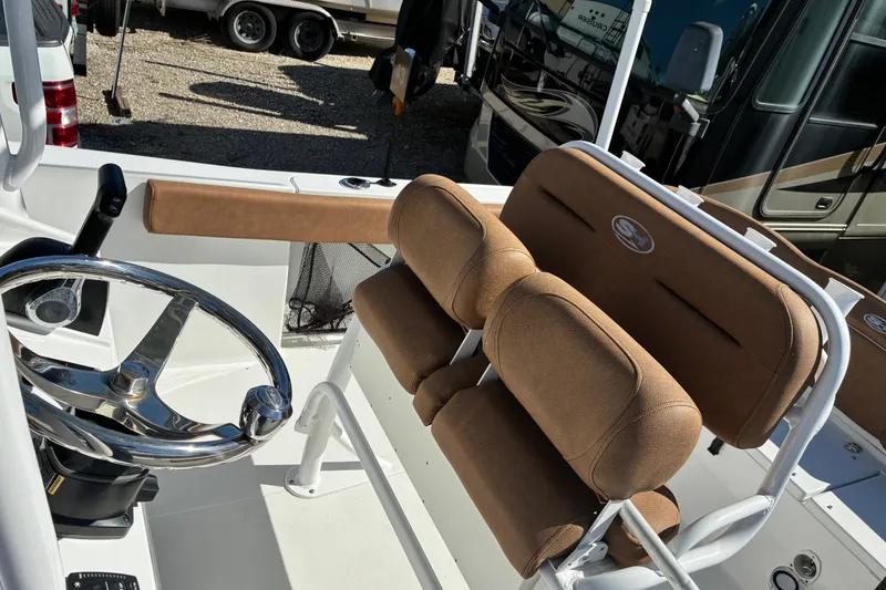 Slide: The Image of 2023 Sea Hunt Ultra 229 boat interior with steering wheel and cushioned seating. - 23